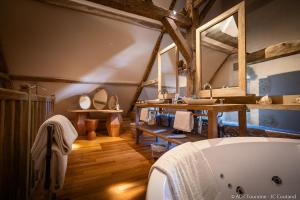 een badkamer met een ligbad en een wastafel bij Hôtel du Château du Rivau in Lémeré