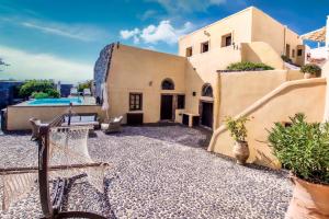 an exterior view of a house with a swimming pool at Santorini Heritage Villas in Megalochori