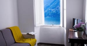 - un salon avec une chaise et une fenêtre dans l'établissement Da Mimmo e Dora, à Blevio