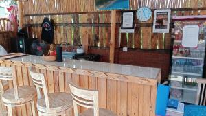 a restaurant with a bar with chairs and a clock at Melasti Mountain Villas, Amed, Room 1, Agung Guesthouse, in Amed