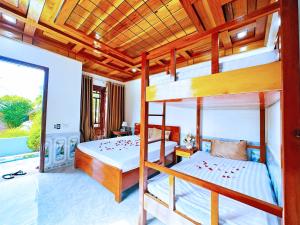 a bedroom with two bunk beds and a balcony at The Hillside Homes in Phong Nha