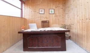 una scrivania in legno con un computer portatile sopra di Treebo Trend Daak Bangla Retreat With Mountain View a Shimla