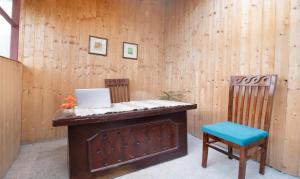 a room with a desk with a laptop and two chairs at Treebo Trend Daak Bangla Retreat With Mountain View in Shimla
