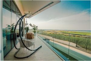 a swinging bench on a balcony of a building at Private Pool & Beach At Your Doorstep in Abu Dhabi