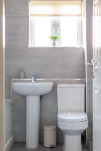 łazienka z umywalką, toaletą i oknem w obiekcie The Walthamstow Collection w Londynie