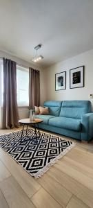 a living room with a blue couch and a table at Apartmán Soul 200 m do centra s private parking in Košice