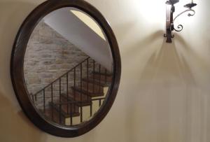 a mirror hanging on a wall with a staircase at Los Cuatro Caños in Sigüenza