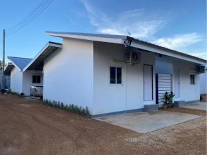 une petite maison blanche avec un terrain de terre dans l'établissement Cheap N Clear Budget Accommodation, à Songkhla