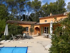 uma villa com piscina em frente a uma casa em La Bastine em Lorgues