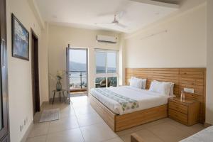 a bedroom with a bed and a large window at Golden Healing Journeys Homestay in Rishīkesh