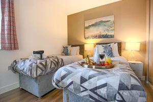 a hotel room with two beds with a tray of fruit at Luxury Detached House with Pool Table, Fast Wi-Fi, Smart TVs and Driveway Parking by Yoko Property in Milton Keynes