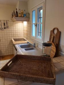 une cuisine avec un évier et une fenêtre dans l'établissement La Bastine, à Lorgues