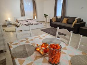 a living room with a table with a vase of fruit at Varázslakos Tanya in Soltvadkert