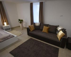 ein Wohnzimmer mit einem grauen Sofa und gelben Kissen in der Unterkunft Varázslakos Tanya in Soltvadkert