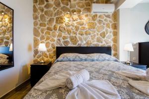 a bedroom with a bed and a stone wall at INFINITY BLUE in Agní