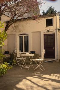 dos sillas y una mesa frente a una casa en L'Escapade Place Voltaire, en Vermenton