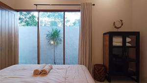 a bedroom with a bed and a large glass window at Casa Benna - Salatiga in Salatiga