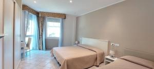 sypialnia z 2 łóżkami i oknem w obiekcie Hotel Viña del Mar Pineta w mieście Lido di Jesolo