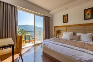 a bedroom with a bed and a large window at Pine Maderas by Embrace in Kasauli +71 photos