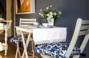 Il Giardino di Ortensia B&B في بيينْتينا: طاولة زرقاء وبيضاء وكراسي بها صحون واكواب