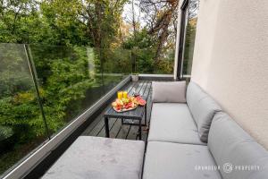 uma varanda com um sofá e uma mesa com um prato de fruta em NEW Elegant apartment, 2 bed, balcony, Poole - Aurora's Abode em Parkstone