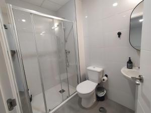 y baño con ducha, aseo y lavamanos. en Casa completa triplex & parking by Gades Gestión, en Cádiz