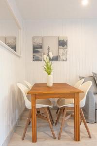 a dining room with a wooden table and white chairs at Apartamento Nature in Sierra Nevada +15 photos
