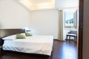 een slaapkamer met een bed, een stoel en een raam bij Marina 10 Boutique&Design Hotel in Ischia