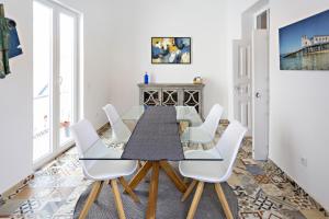 a dining room with a table and white chairs at Alagoa Apartments in Tavira