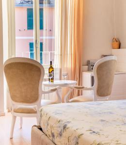 a room with two chairs and a table and a bed at Alla Marina Affittacamere in Riomaggiore
