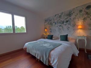 ein Schlafzimmer mit einem großen Bett mit Blumenwand in der Unterkunft Maison Au P'tit Bonheur in Argenton-sur-Creuse