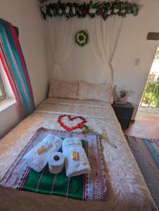 a bed with blankets and towels on top of it at Casa vivencial Mamá Vivi in Coporaque