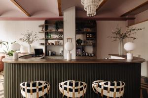 a bar with three stools in a room at NEWLY OPENED - Parklane Hotel in Amsterdam