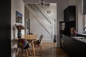 a kitchen with a table and chairs and a staircase at Sanctum Boutique Apartments in Hobart