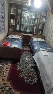een slaapkamer met 2 bedden en een tapijt bij HOSTEL TASMIN MEXR in Samarkand