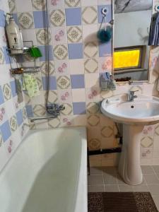 een badkamer met een bad en een wastafel bij HOSTEL TASMIN MEXR in Samarkand