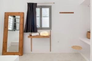 a room with a mirror and a shelf and a window at Windmill House with private pool and breathtaking views in Andiparos +34 photos