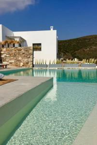 a swimming pool with blue water in front of a building at Windmill House with private pool and breathtaking views in Andiparos