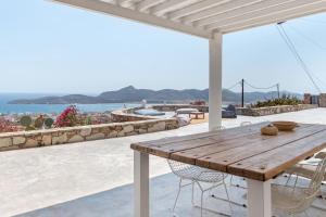 a wooden table on a patio with a view of the ocean at Windmill House with private pool and breathtaking views in Andiparos