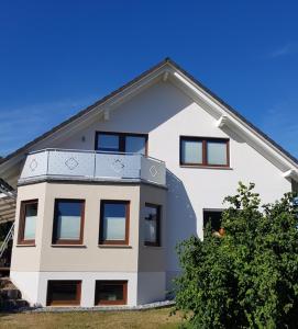 Casa blanca con balcón en la parte superior. en Harzer Auszeit en Hattorf