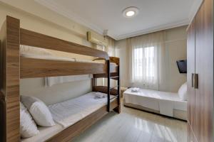 a room with two bunk beds and a window at Hikmethan Otel in Kusadası