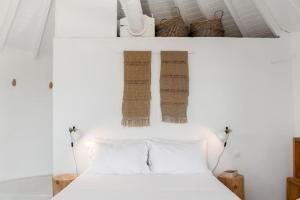 a bedroom with white walls and a bed with white pillows at Windmill House with private pool and breathtaking views in Andiparos