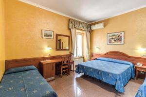 a bedroom with two beds and a desk and a mirror at Hotel Milo in Rome