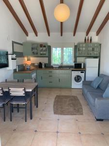 uma cozinha e sala de estar com uma mesa e um sofá em Casita in Javea with garden and pool - dog friendly! em Xàbia