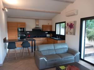a living room with a couch and a kitchen at fiori 1 in Sainte-Lucie de Porto-Vecchio