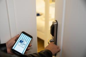 a person holding a cell phone in front of a door at Le residenze del capitano in Bari