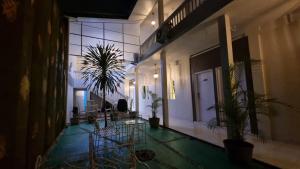 a hallway with plants and a table and chairs at Sukun Boutique Hotel Cilacap Managed by GHM in Cilacap