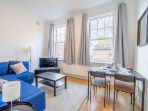a living room with a blue couch and a table at Pass the Keys Cosy 2 Bedroom Apartment near city centre in Nottingham