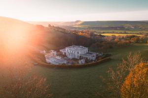 eine Luftansicht eines großen weißen Hauses auf einem Feld in der Unterkunft The West Wing - Bride Valley - Jurassic Coast in Long Bredy