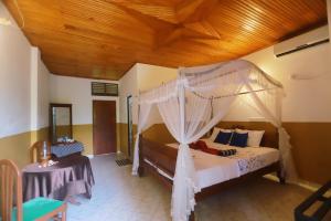 Schlafzimmer mit Himmelbett und Holzdecke in der Unterkunft The Green Heaven Resort in Sigiriya